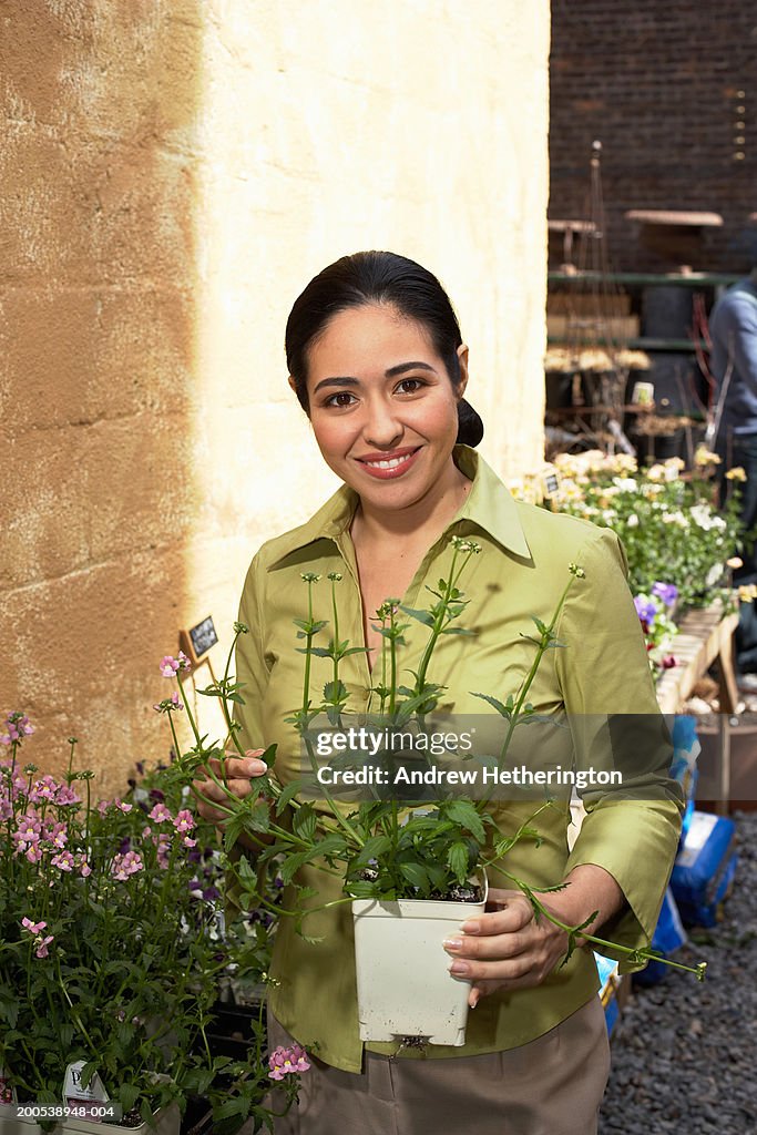 Female florist holding potted plant