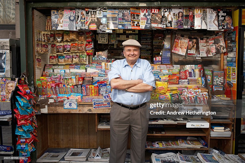 News and magazine kiosk operator in front of stand, portrait