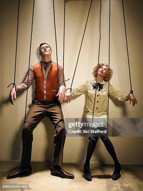 male and female puppets tied with strings - puppeteer photos et images de collection