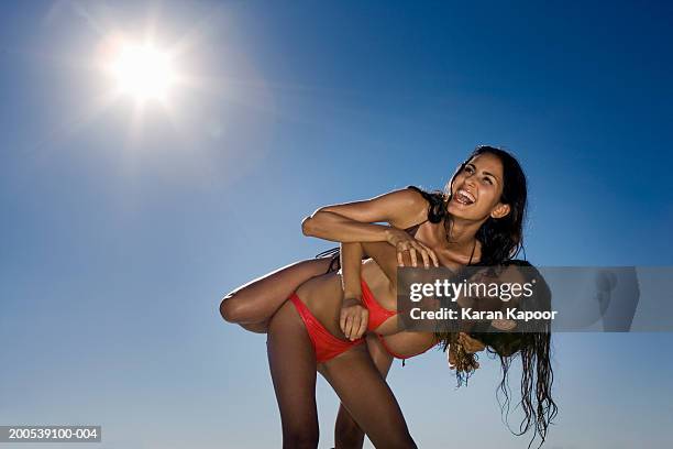 two young women messing about against blue sky, laughing - blue sky friends photos et images de collection