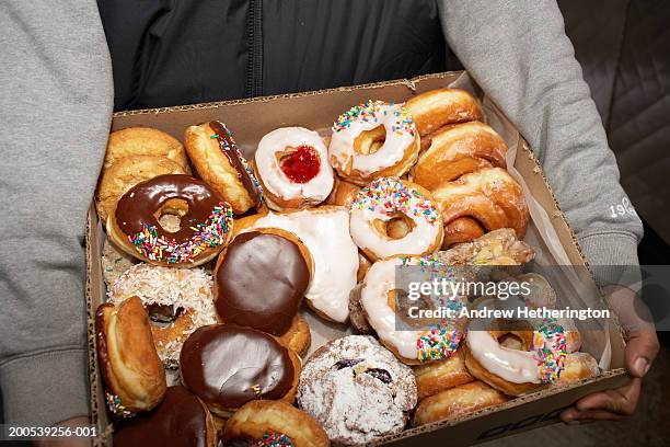 street vendor carrying box of doughnuts, mid section, elevated view - bombolone foto e immagini stock