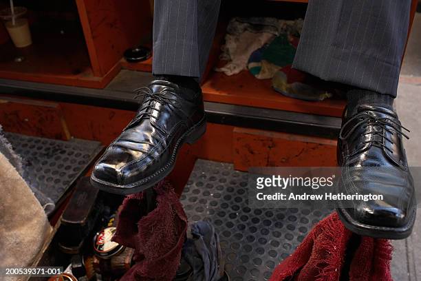 man sitting on shoeshine chair, close-up, low section - shoeshiner stock pictures, royalty-free photos & images