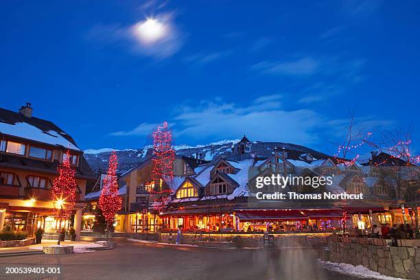 canada, british columbia, moon over whistler village at dusk - whistler winter stock-fotos und bilder