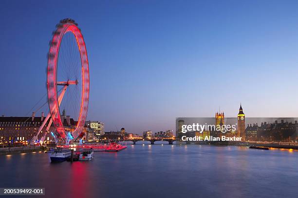 uk, london, river thames, millennium wheel illuminated at dusk - london eye stockfoto's en -beelden