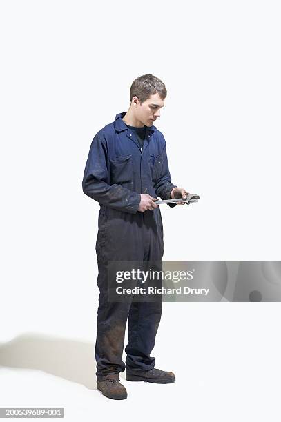 young man wearing boiler suit holding wrench - overalls stock pictures, royalty-free photos & images