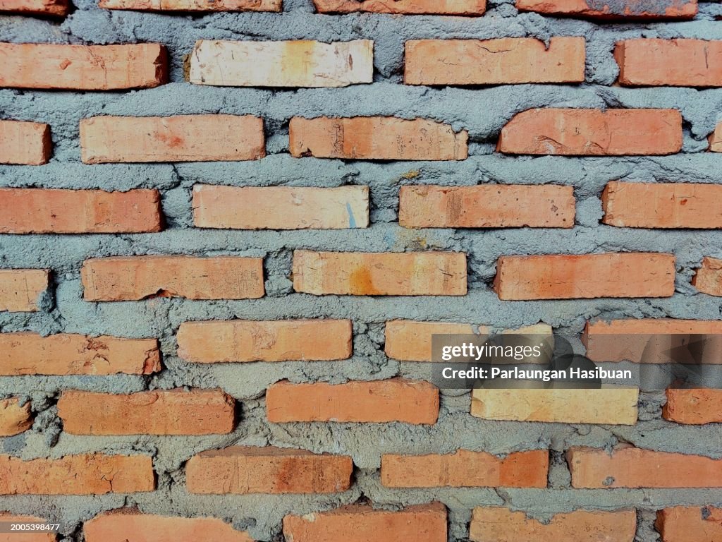The background of a wall is made and composed of bricks and cement