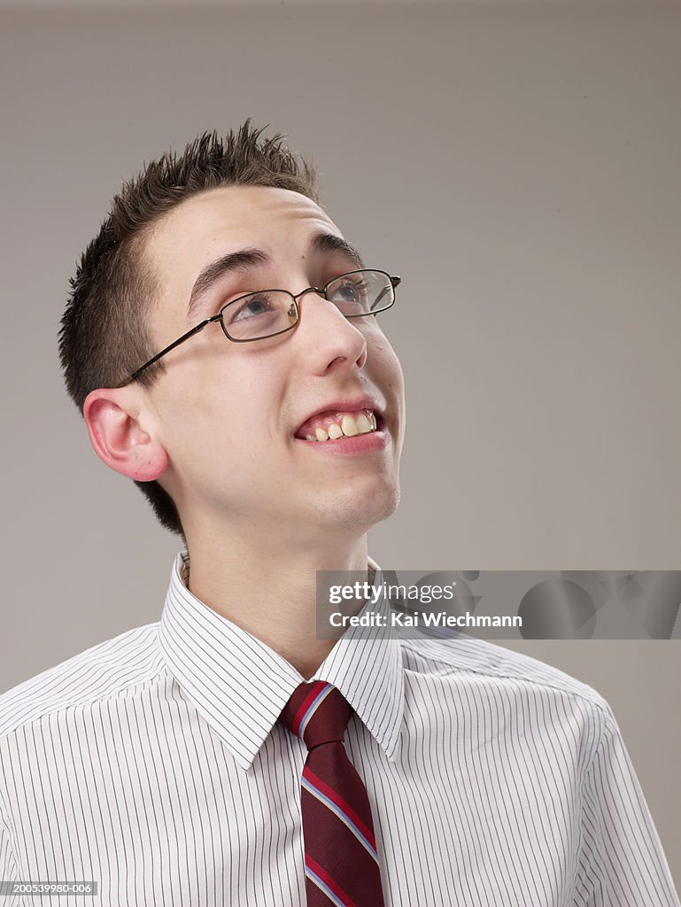 Businessman wearing glasses, looking upwards