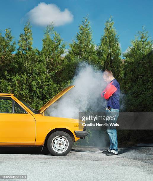 man looking at yellow car with steam pouring from bonnet - vehicle breakdown bildbanksfoton och bilder