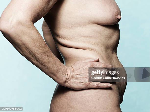 naked senior woman with arms akimbo, mid section, side view - poitrine photos et images de collection