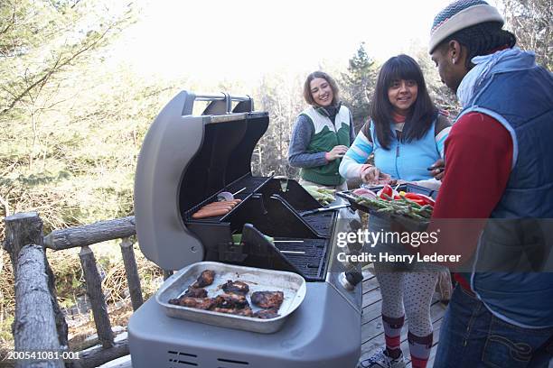 young people grilling food on porch - bbq winter photos et images de collection