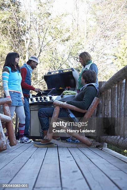 young people grilling food on porch, winter - bbq winter ストックフォトと画像