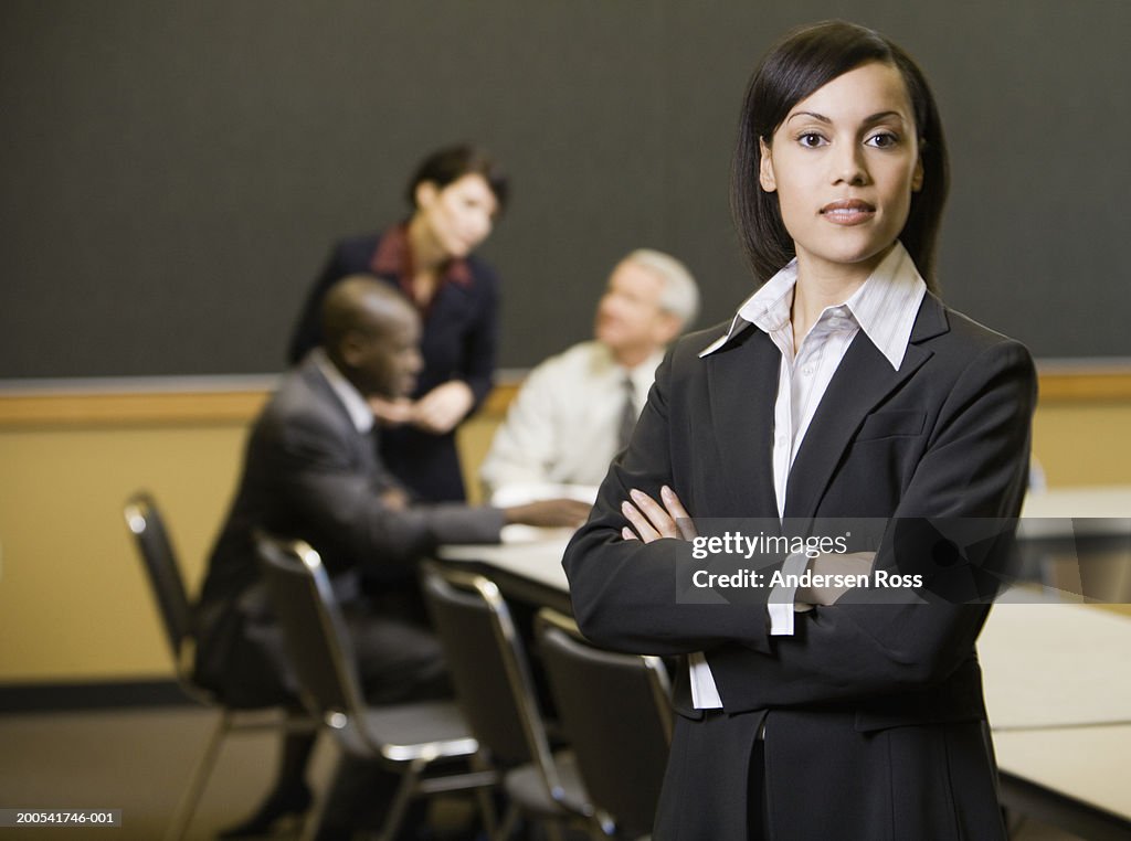 Four executives in conference room (focus on woman in foreground)