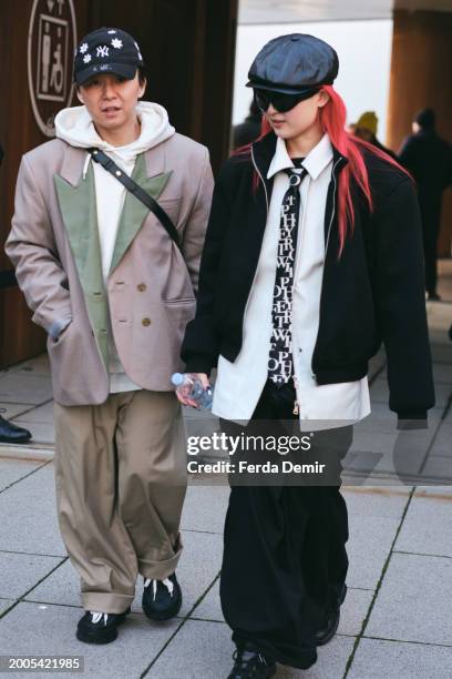 Guests wears black zip up jacket, white shirt, black printed tie, black baggcargo pats, leather warm octagonal cap, Gucci 3D flower cap, Plateau 10b...