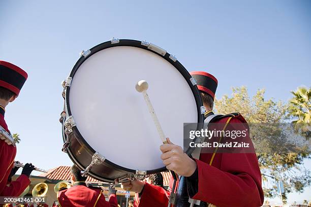 marching band drummer holding bass drum - paraden stock-fotos und bilder