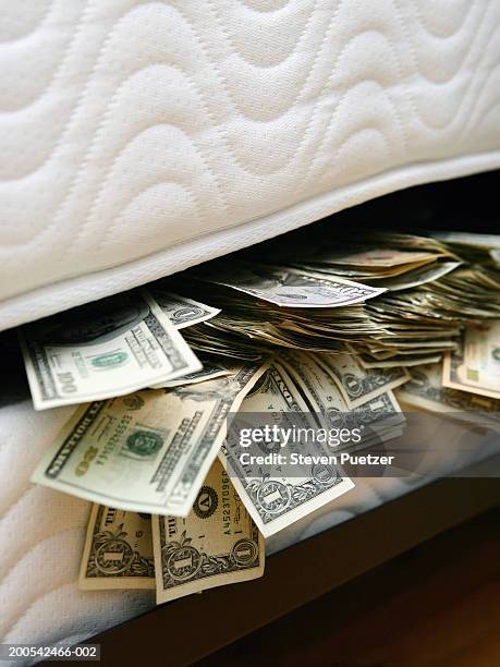 us banknotes stuffed between mattresses, close-up - hiding money stock pictures, royalty-free photos & images