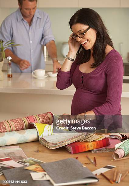 pregnant woman looking through wallpaper designs, using telephone - messy boyfriend stock pictures, royalty-free photos & images