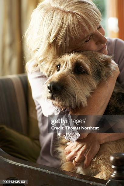 mature woman hugging dog - hugging a chair stock pictures, royalty-free photos & images