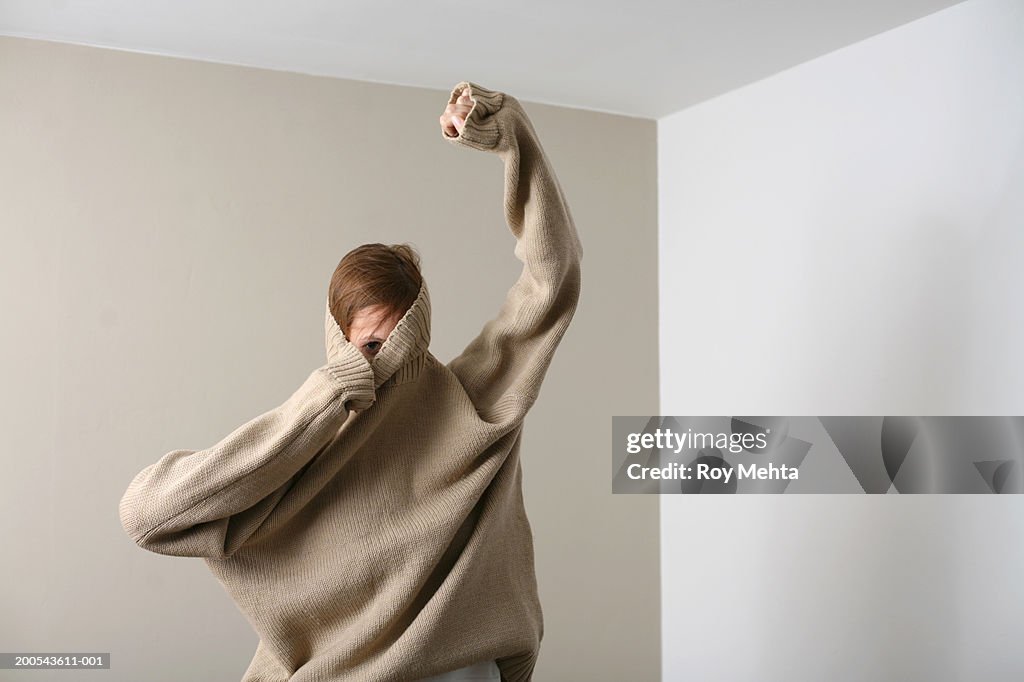 Woman putting on sweater