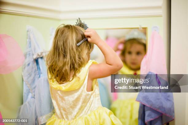 girl (2-4) in princess costume adjusting tiara in mirror, rear view - princesa fotografías e imágenes de stock