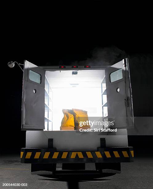 Yellow Money Bags Sitting In Open Rear Doors Of Armored Truck High-Res Stock Photo