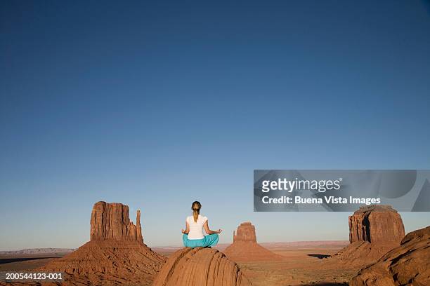 usa, arizona, monument valley, woman in yoga position, rear view - world at your fingertips stockfoto's en -beelden