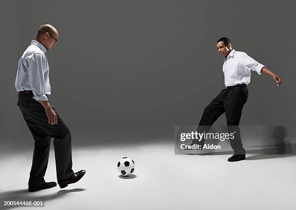 two businessmen playing football, studio shot - two guys playing soccer stockfoto's en -beelden