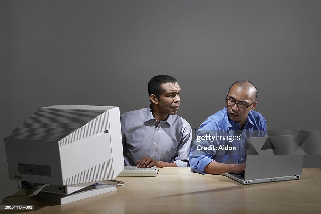 Businessmen using old and new computer technology