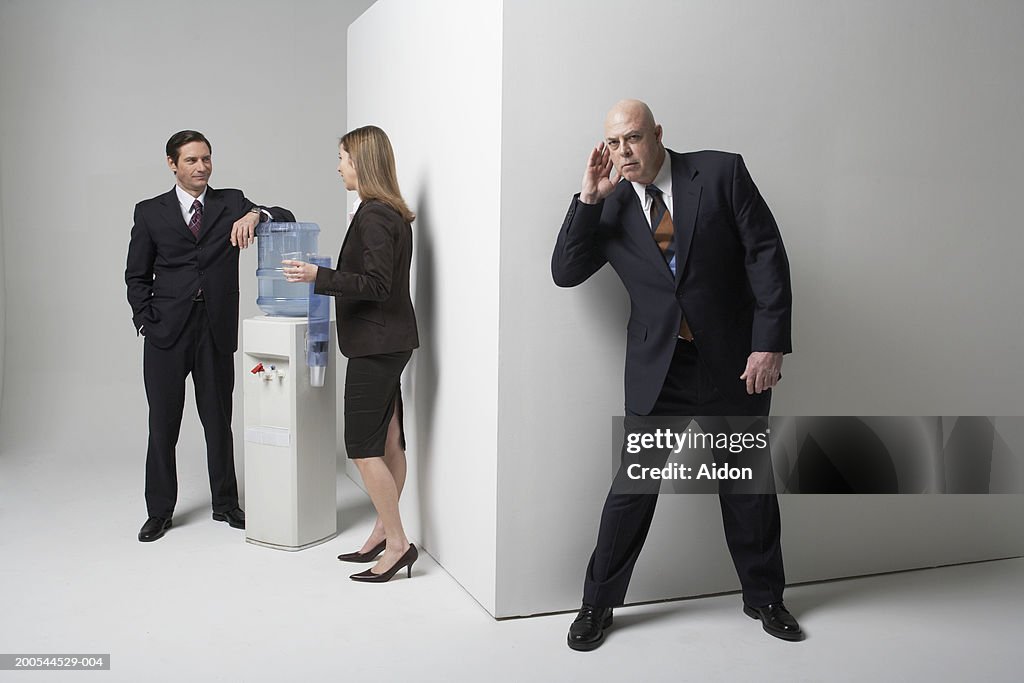 Businessman listening to colleagues conversation, studio shot