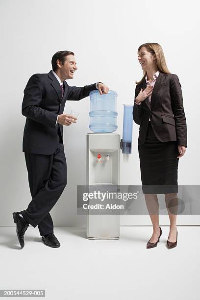 business colleagues talking by water cooler, studio shot - water cooler white background stock pictures, royalty-free photos & images