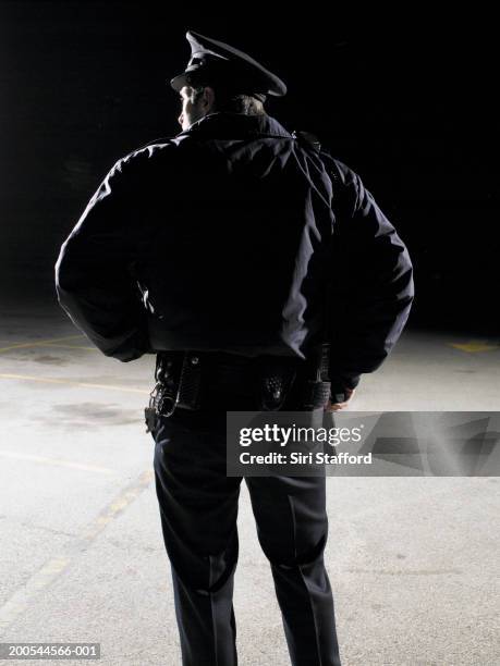 security guard with hand on gun, rear view - agent de sécurité photos et images de collection