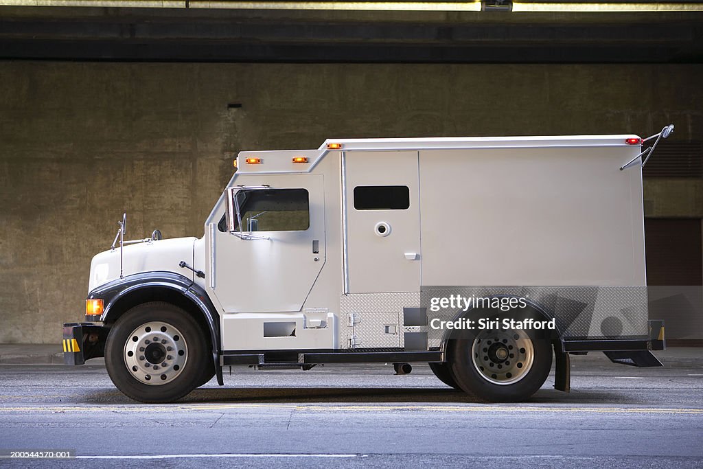 Armored truck on city street, side view