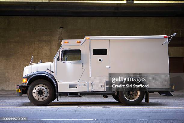 armored truck on city street, side view - véhicule blindé photos et images de collection
