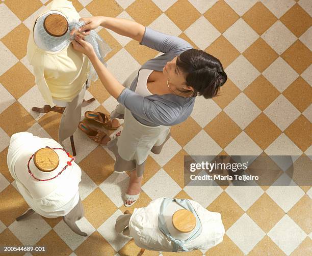 woman dressing mannequin, elevated view - mannequin stock pictures, royalty-free photos & images