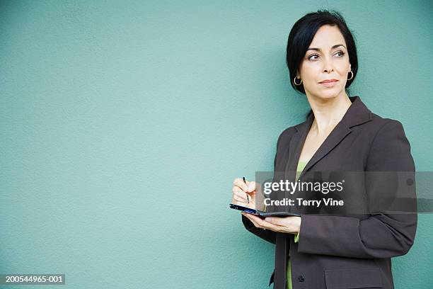 mature businesswoman using palmtop, looking away - palm photos et images de collection