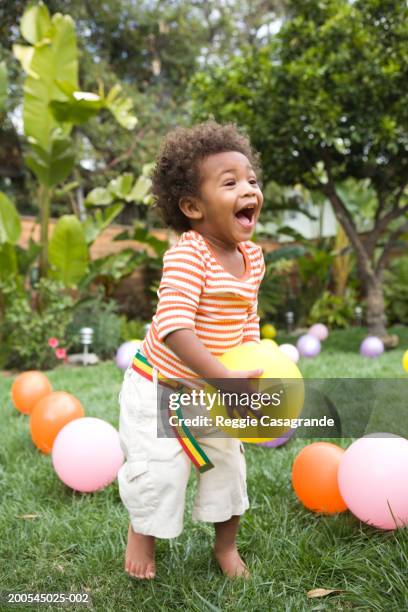 toddler boy (21-24 months) playing with balloons in yard - black balloon stock-fotos und bilder