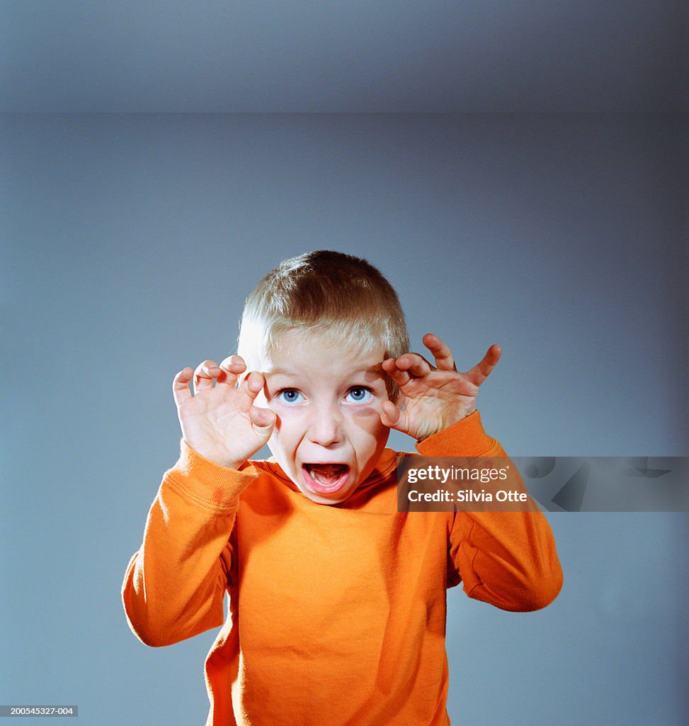 Boy (4-5) pulling funny faces, close-up