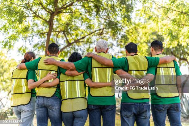recicladores abrazados en parque público - responsabilidad social fotografías e imágenes de stock
