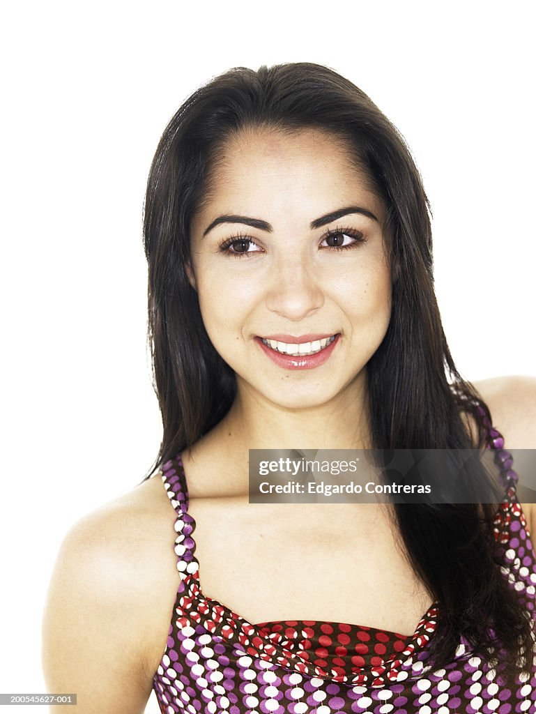 Young woman, smiling in studio, head and shoulders