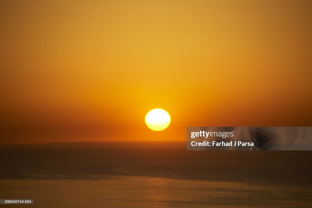 Sun setting over ocean