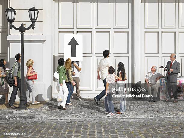 man standing in street holding placard with arrow pointing upwards - persuasion stock pictures, royalty-free photos & images