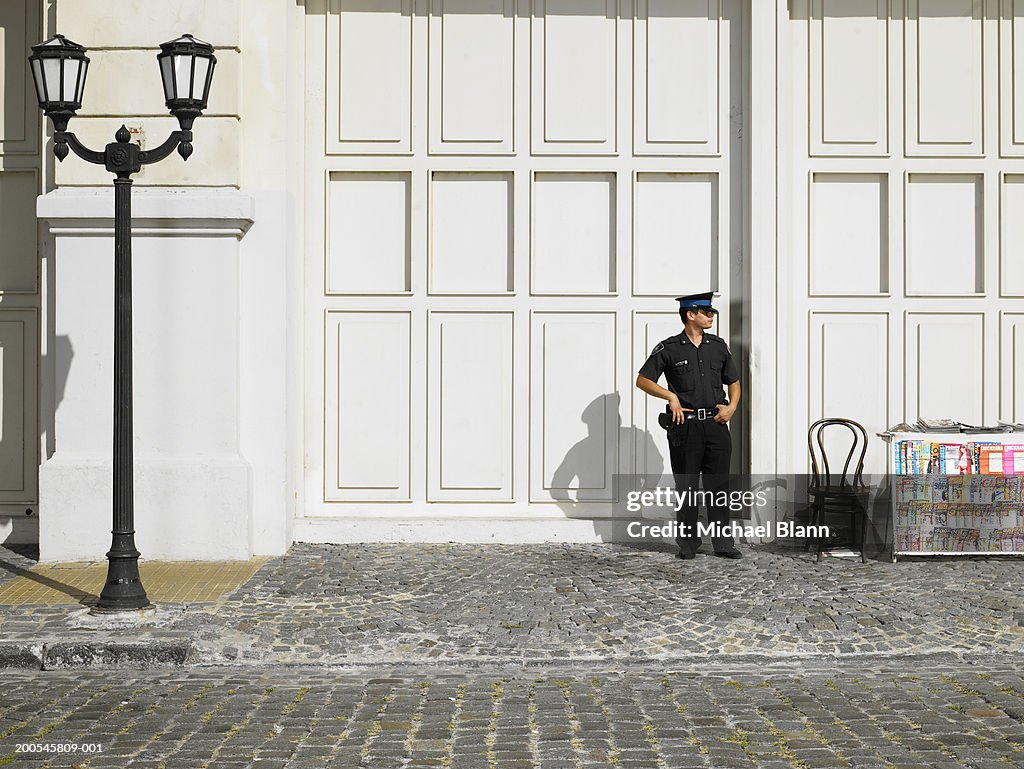 Policeman standing by stall in street