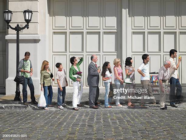 long queue of people in street, side view - waiting stock-fotos und bilder