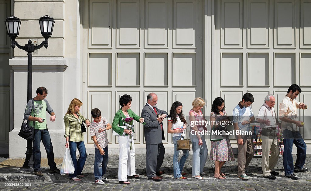 Long queue of people in street, side view