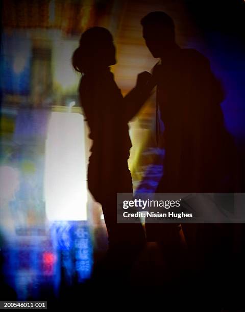 silhouette of couple dancing, projected background - couple dark background stock-fotos und bilder