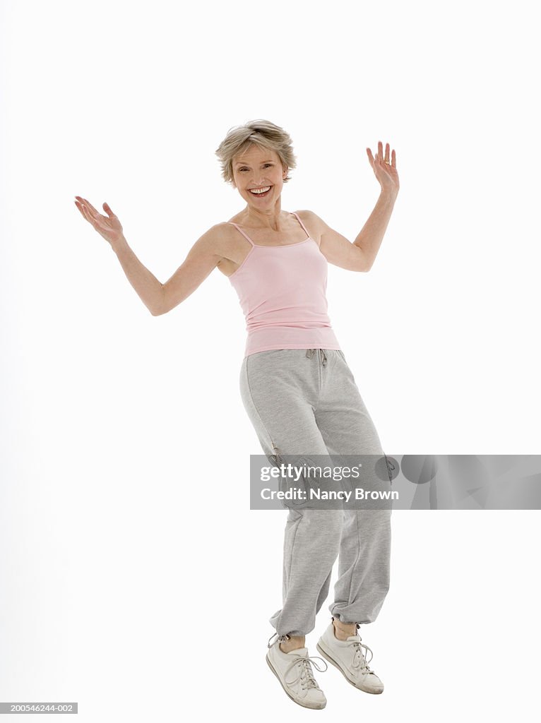 Senior woman jumping, smiling, portrait