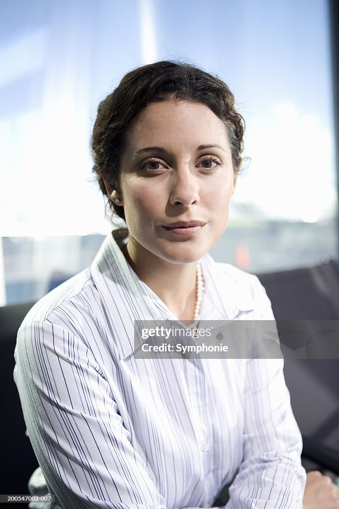 Businesswoman sitting in airport lounge, portrait, close-up