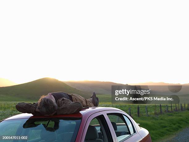 man lying on car roof, hands behind head - mill valley stock pictures, royalty-free photos & images