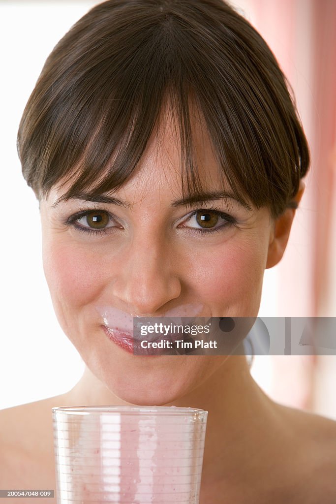 Young Woman drinking fruit smoothie, close-up, portrait