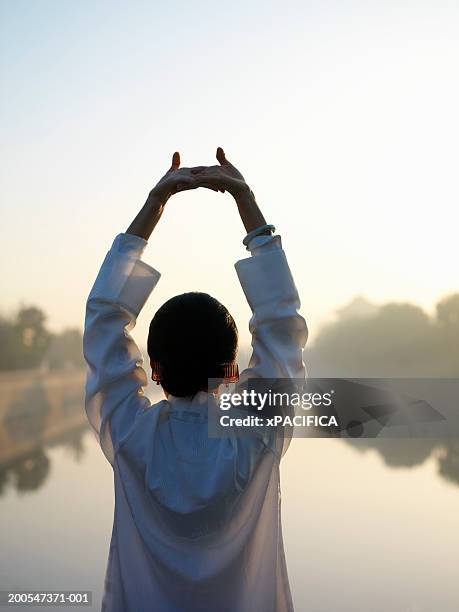 chinese woman performing tai chi exercises by lake at forbidden city - tai chi stock pictures, royalty-free photos & images