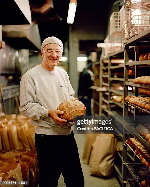 bakery owner holding bread in storage room, portrait - america patisserie stock pictures, royalty-free photos & images